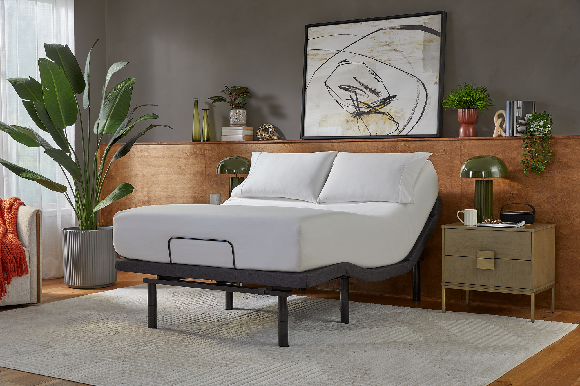 Bed with adjustable base in a bedroom setting with decor elements.